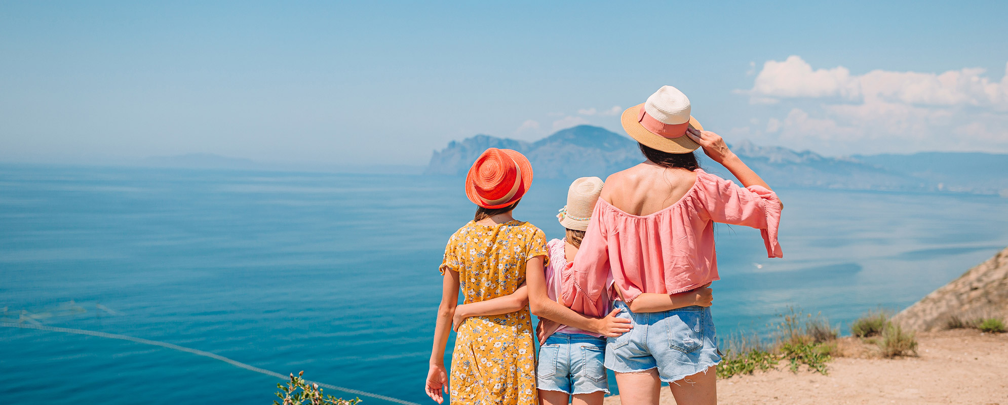 mère et ses deux filles admirant la mer en été